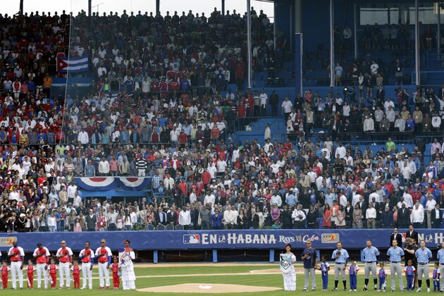 Tampa Bay Rays and the Cuban National team stand as the national anthems are played before their match in Havana, Cuba, Tuesday March 22, 2016. The crowd roared as U.S. President Barack Obama and Cuban President Raul Castro entered the stadium and walked toward their seats in the VIP section behind home plate. It's the first game featuring an MLB team in Cuba since the Baltimore Orioles played in the country in 1999. (AP Photo/Ramon Espinosa)