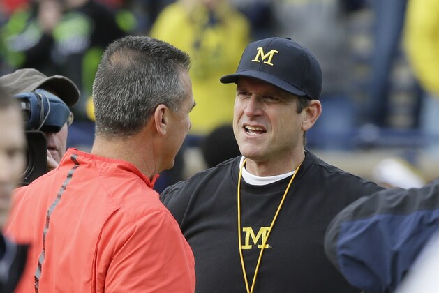 Ohio State head coach Urban Meyer, left, meets with Michigan head coach Jim Harbaugh before the first half of an NCAA college football game, Saturday, Nov. 28, 2015, in Ann Arbor, Mich. (AP Photo/Carlos Osorio)