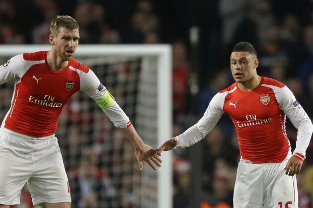 Arsenal's Alex Oxlade-Chamberlain, right, stands with Per Mertesacker after scoring a goal in the Champions League round of 16 soccer match between Arsenal and AS Monaco at the Emirates Stadium in London, Wednesday, Feb. 25, 2015.  Monaco won the match 3-1.  (AP Photo/Matt Dunham)