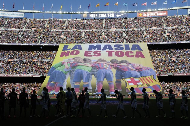 Barcelona's supporters unveil a giant banner reading in Catalan 'La Masia, don't touch it' before the Spanish league football match FC Barcelona vs Real Betis at the Camp Nou stadium in Barcelona.  AFP PHOTO / JOSEP LAGO        (Photo credit should read JOSEP LAGO/AFP/Getty Images)