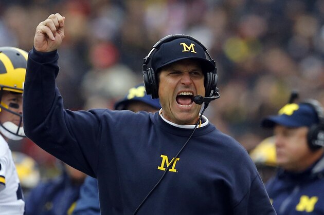 FILE - In this Oct. 3, 2015, file photo, Michigan head coach Jim Harbaugh calls for a flag in the first half of an NCAA college football game against Maryland in College Park, Md. Michigan and Florida both entered the season hoping to revive storied programs that had begun to look more pedestrian than they were accustomed to. Enter Wolverines coach Harbaugh and Gators coach Jim McElwain, who both brought their own style and approach to the sidelines in their first seasons on the job. (AP Photo/Patrick Semansky, File)