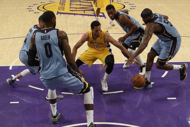 Los Angeles Lakers guard Jordan Clarkson, center, movies the ball defended by Memphis Grizzlies forward Zach Randolph, right, during the second half of an NBA basketball game in Los Angeles, Tuesday, March 22, 2016. The Los Angeles Lakers won 107-100. (AP Photo/Kelvin Kuo)