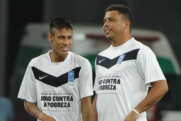 Brazilian football player Ronaldo (R) and Neymar speak before their 'Match Against Poverty' friendly football match led by the United Nations Development Programme (UNDP), between the teams 'Friends of Ronaldo' and 'Friends of Zidane' in southern Brazil's Porto Alegre on December 19, 2012.  AFP PHOTO / Yasuyoshi CHIBA        (Photo credit should read YASUYOSHI CHIBA/AFP/Getty Images)