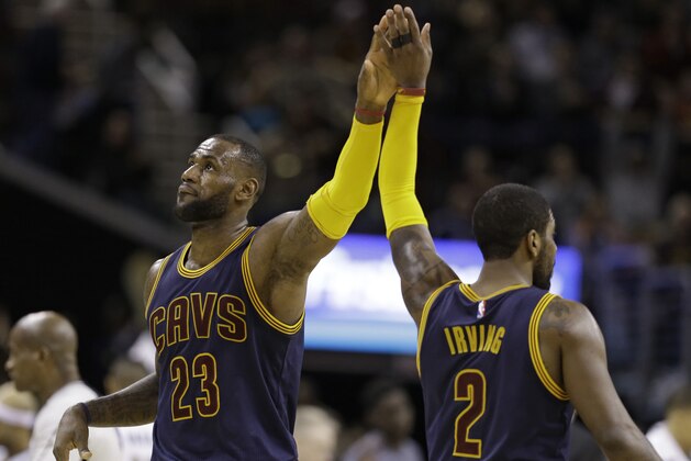 Cleveland Cavaliers' LeBron James, left, and Kyrie Irving celebrate late in the second half of an NBA basketball game against the Milwaukee Bucks, Wednesday, March 23, 2016, in Cleveland.  The Cavaliers won 113-104. (AP Photo/Tony Dejak)