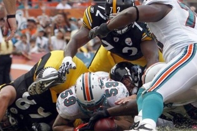 FILE - In this file photo taken Oct. 24, 2010, Miami Dolphins linebacker Karlos Dansby (58) lands on the ball fumbled by Pittsburgh Steelers quarterback Ben Roethlisberger in the second half of an NFL football game in Miami. When a football hits the ground, players are known to do whatever it takes to get it. Nothing is off limits.  Even quarterbacks sometimes get involved in all that craziness at the bottom of a pileup. Steelers' Roethlisberger was right in the middle of an end-zone scrum during a controversial play that led to Pittsburgh's 23-22 win at Miami last Sunday. (AP Photo/Alan Diaz, File)