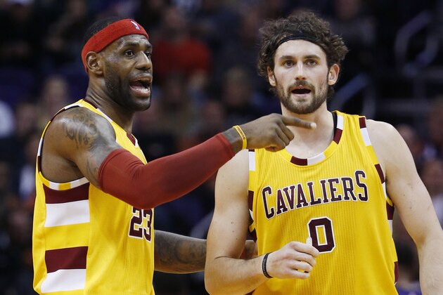 Cleveland Cavaliers' LeBron James (23) and Kevin Love (0) talk after a timeout during the first half of an NBA basketball game against the Phoenix Suns on Monday, Dec. 28, 2015, in Phoenix. (AP Photo/Ross D. Franklin)