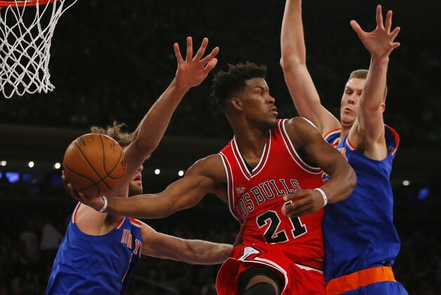 Mar 24, 2016; New York, NY, USA; Chicago Bulls guard Jimmy Butler (21) looks to pass the ball between New York Knicks center Robin Lopez (8) and forward Kristaps Porzingis (6) during first half at Madison Square Garden. Mandatory Credit: Noah K. Murray-USA TODAY Sports