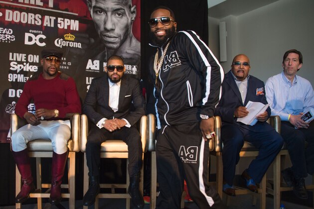 WBA super lightweight champion Adrien Broner (C) smiles as he walks past his upcoming opponent Ashley Theophane (2nd L) as promoter and former champion boxer Floyd Mayweather (L) look on during a press conference in Washington, DC, February 29, 2016.  
The title contest is scheduled to take place April 1, 2016 at the D.C. Armory in Washington DC. / AFP / JIM WATSON        (Photo credit should read JIM WATSON/AFP/Getty Images)