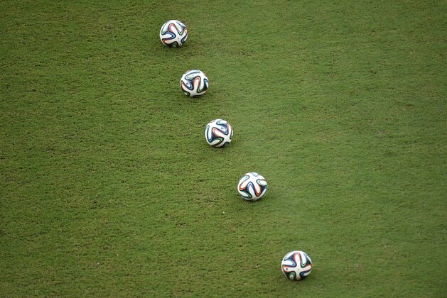 Official Brazuca balls lay on the pitch prior to a Group G football match between USA and Portugal at the Amazonia Arena in Manaus during the 2014 FIFA World Cup on June 22, 2014.     AFP PHOTO / FABRICE COFFRINI        (Photo credit should read FABRICE COFFRINI/AFP/Getty Images)