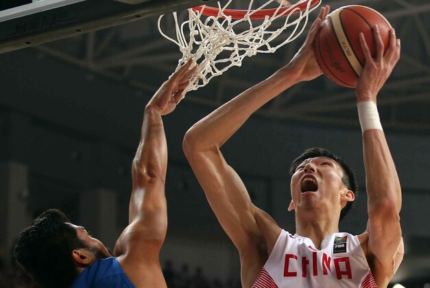 China's Zhou Qi  (R) goes to the basket as the Philippines' Ranidel De Ocampo (L) defends the during the final match  between China and Philippines at the FIBA Asia Basketball championship on October 3, 2015 in Changsha.  AFP PHOTO    ==CHINA OUT==        (Photo credit should read STR/AFP/Getty Images)