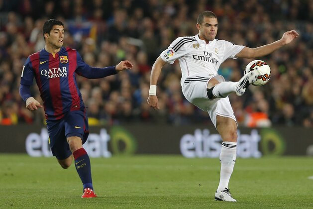 Real Madrid's Pepe plays the ball with Barcelona's Luis Suarez, left, during a Spanish La Liga soccer match between FC Barcelona and Real Madrid at Camp Nou stadium, in Barcelona, Spain, Sunday, March 22, 2015. (AP Photo/Emilio Morenatti)