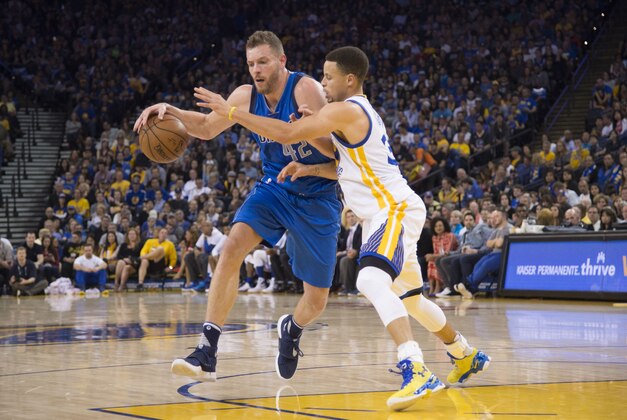 March 25, 2016; Oakland, CA, USA; Dallas Mavericks forward David Lee (42) dribbles the basketball against Golden State Warriors guard Stephen Curry (30) during the second quarter at Oracle Arena. Mandatory Credit: Kyle Terada-USA TODAY Sports