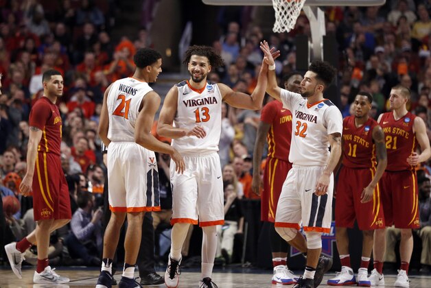 Virginia's Anthony Gill (13) celebrates with Virginia's Isaiah Wilkins (21) and London Perrantes (32) after a play in the final seconds of a college basketball game against Iowa State in the regional semifinals of the NCAA Tournament, Friday, March 25, 2016, in Chicago. (AP Photo/Charles Rex Arbogast)