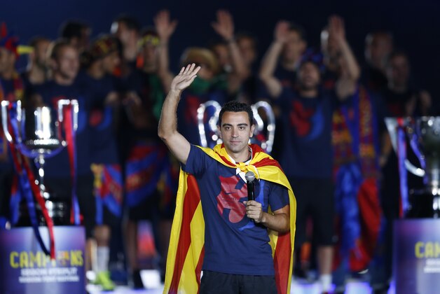 Barcelona's Xavi Hernandez waves to the fans during celebrations at the Camp Nou stadium in Barcelona, Spain Sunday June 7, 2015 after winning the Champions League final soccer match Saturday by beating Juventus Turin 3-1. Barcelona won the triple this season winning the Spanish League title, the Copa del Rey and the Champions League. (AP Photo/Manu Fernandez)