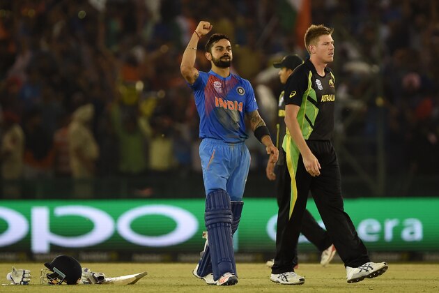 India's Virat Kohli(L) celebrates after victory as Australia's James Faulkner looks on in the World T20 cricket tournament match between India and Australia at The Punjab Cricket Stadium Association Stadium in Mohali on March 27, 2016. / AFP / MONEY SHARMA        (Photo credit should read MONEY SHARMA/AFP/Getty Images)