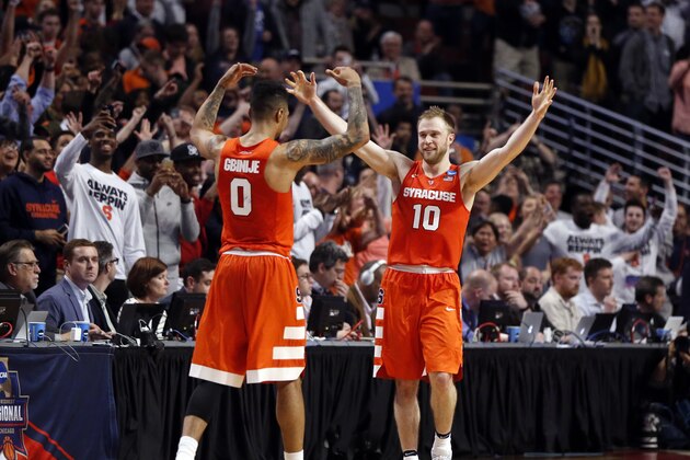 Syracuse's Michael Gbinije (0) and Trevor Cooney (10) celebrate after a college basketball game against Virginia in the regional finals of the NCAA Tournament, Sunday, March 27, 2016, in Chicago. Syracuse won 68-62. (AP Photo/Charles Rex Arbogast)