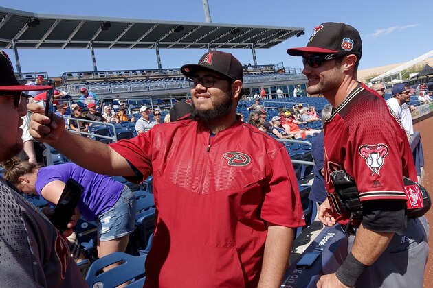 Arizona Diamondbacks' A.J. Pollock, right, poses for a photograph with a fan prior to a spring training baseball game against the San Diego Padres Tuesday, March 8, 2016, in Peoria, Ariz. (AP Photo/Ross D. Franklin)