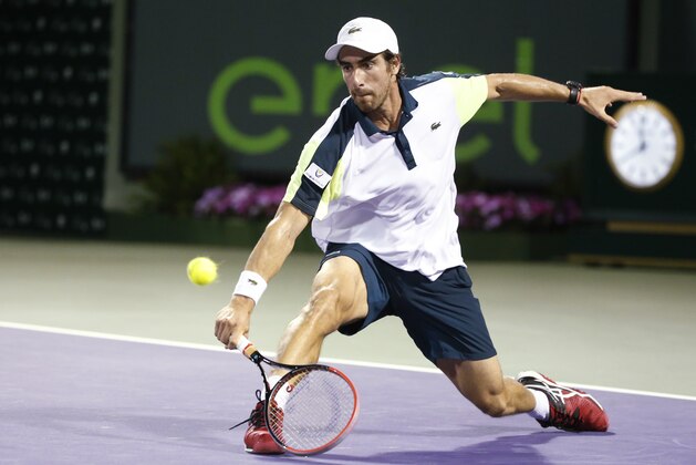 Pablo Cuevas, of Uruguay, returns a shot to Gael Monfils, of France, at the Miami Open tennis tournament, in Key Biscayne, Fla., Monday, March 28, 2016. (AP Photo/Wilfredo Lee)