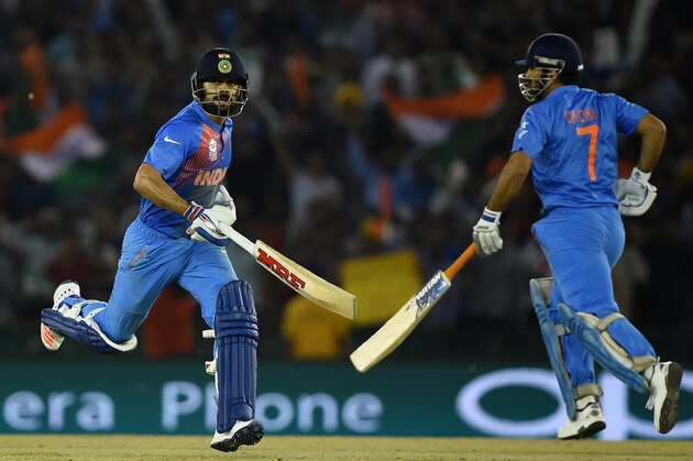 India's captain Mahendra Singh Dhoni(R)and teammate Virat Kohli run between the wickets during the World T20 cricket tournament match between India and Australia at The Punjab Cricket Stadium Association Stadium in Mohali on March 27, 2016. / AFP / MONEY SHARMA        (Photo credit should read MONEY SHARMA/AFP/Getty Images)