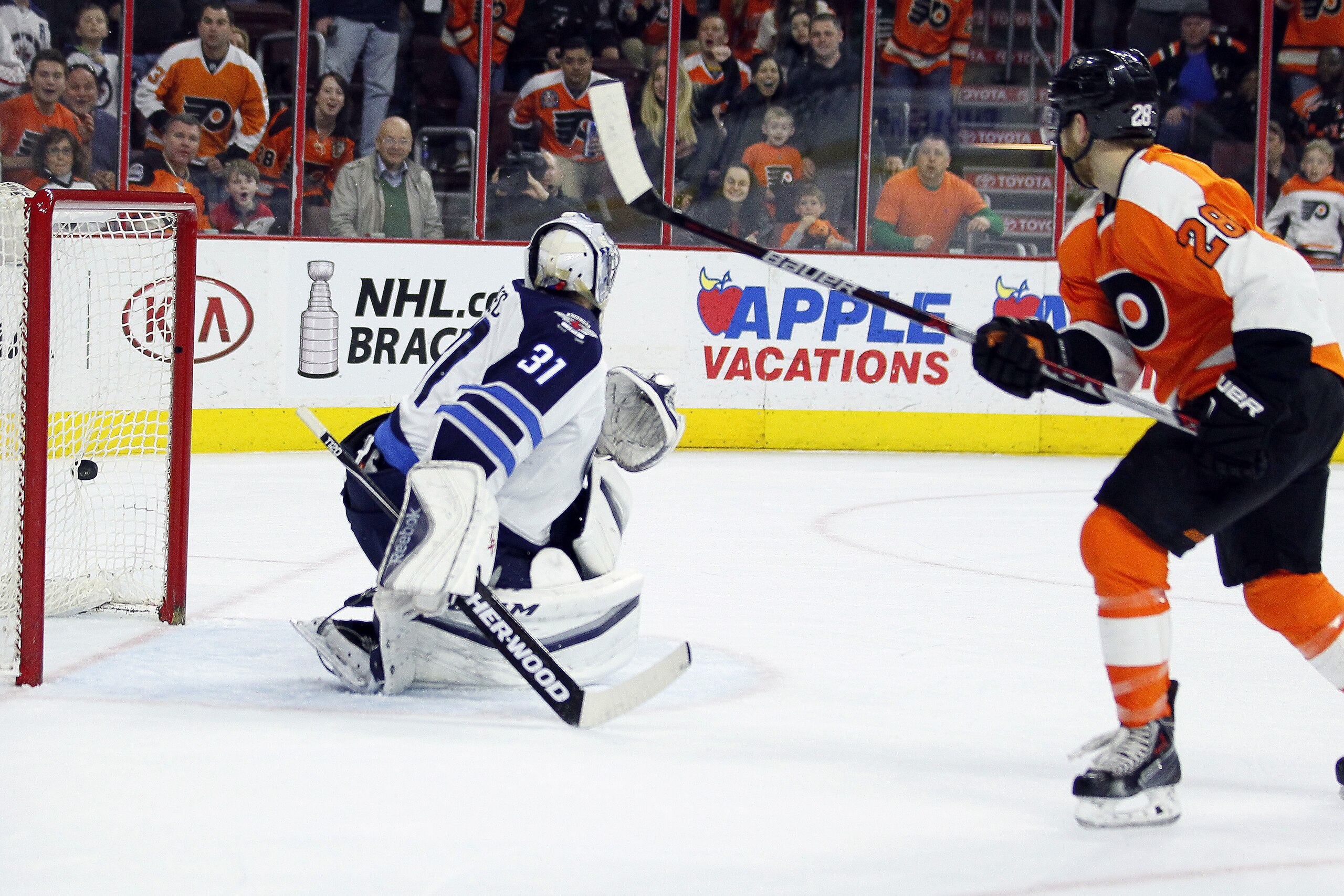 The game-winning goal by Philadelphia Flyers' Claude Giroux, right, is in the net after scoring past Winnipeg Jets' Ondrej Pavelec, left, during the overtime period of an NHL hockey game, Monday, March 28, 2016 in Philadelphia. The Flyers won 3-2.  (AP Photo/Tom Mihalek)