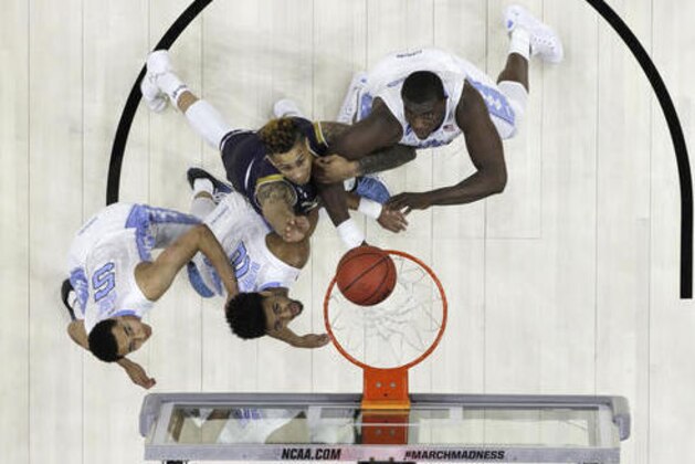 North Carolina's Marcus Paige, from left, Joel Berry II, Notre Dame's Zach Auguste and Joel James battle for a rebound during the first half of a regional final men's college basketball game in the NCAA Tournament, Sunday, March 27, 2016, in Philadelphia. (AP Photo/Chris Szagola)