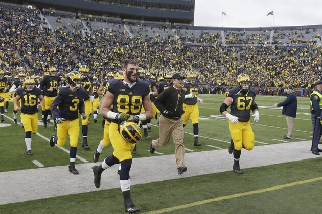 Michigan head coach Jim Harbaugh leads the Michigan team to the locker room before the first half of an NCAA college football game against Ohio State, Saturday, Nov. 28, 2015, in Ann Arbor, Mich. (AP Photo/Carlos Osorio)