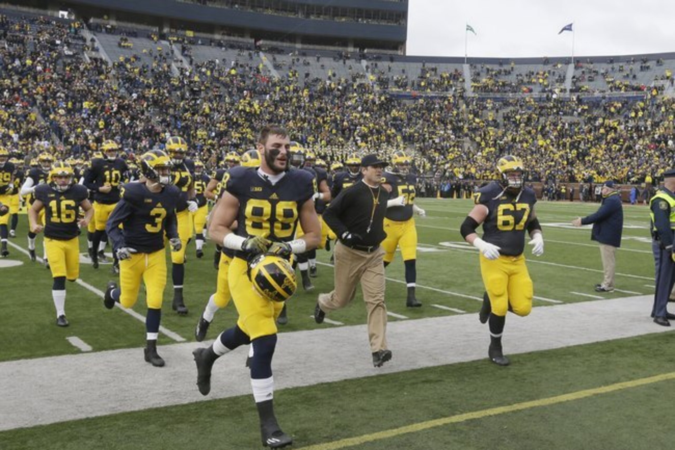 Michigan head coach Jim Harbaugh leads the Michigan team to the locker room before the first half of an NCAA college football game against Ohio State, Saturday, Nov. 28, 2015, in Ann Arbor, Mich. (AP Photo/Carlos Osorio) Michigan head coach Jim Harbaugh leads the Michigan team to the locker room before the first half of an NCAA college football game against Ohio State, Saturday, Nov. 28, 2015, in Ann Arbor, Mich. (AP Photo/Carlos Osorio)