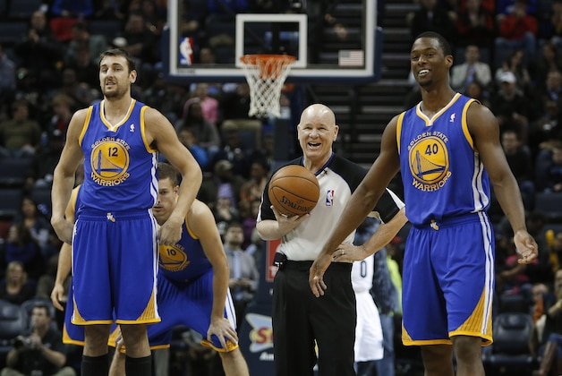 A referee jokes with Golden State Warriors center Andrew Bogut (12), of Australia, and forward Harrison Barnes (40) as they wait to tip off against the Memphis Grizzlies in an NBA basketball game Saturday, Dec. 7, 2013, in Memphis, Tenn. (AP Photo/Lance Murphey)