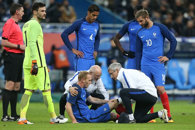 PARIS, FRANCE - MARCH 29: Injured, Jeremy Mathieu of France talks with medical staff of team France while goalkeeper Hugo Lloris (right), Raphael Varan and Andre-Pierre Gignac of France looks on during the international friendly match between France and Russia at Stade de France on March 29, 2016 in Saint-Denis near Paris, France.  (Photo by Jean Catuffe/Getty Images)