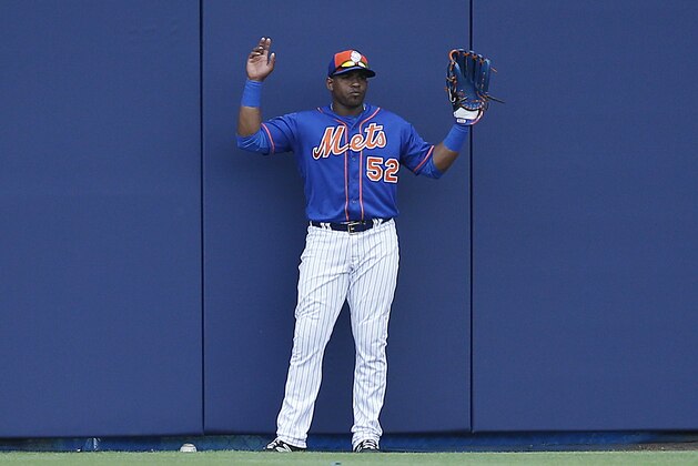 New York Mets' left fielder Yoenis Cespedes, holds up his hands pleading for a ground rule double after Houston Astros' A.J. Reed hit a ball that was stuck under the wall during the second inning of a spring training baseball game, Thursday, March 24, 2016, in Port St. Lucie, Fla. (AP Photo/Brynn Anderson)