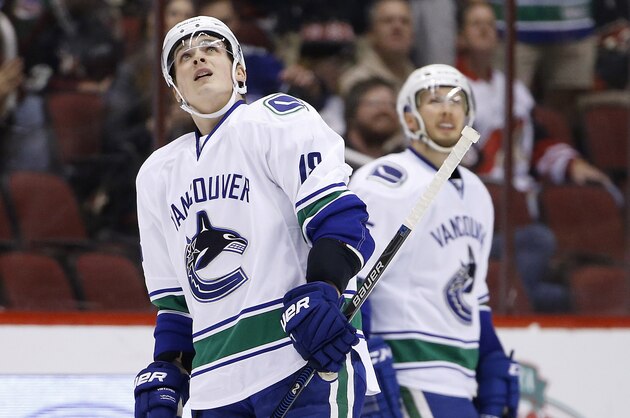 Vancouver Canucks' Jake Virtanen, left, and Alex Biega, right, look up at the scoreboard during the first period of an NHL hockey game against the Arizona Coyotes Wednesday, Feb. 10, 2016, in Glendale, Ariz.  The Canucks defeated the Coyotes 2-1. (AP Photo/Ross D. Franklin)