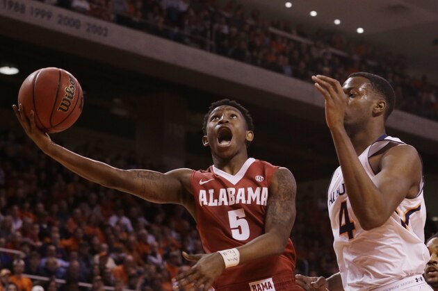 Alabama guard Justin Coleman (5) shoots as Auburn center Trayvon Reed (4) guards during the first half during an NCAA college basketball game Tuesday, Feb. 17, 2015, in Auburn, Ala. (AP Photo/Brynn Anderson)