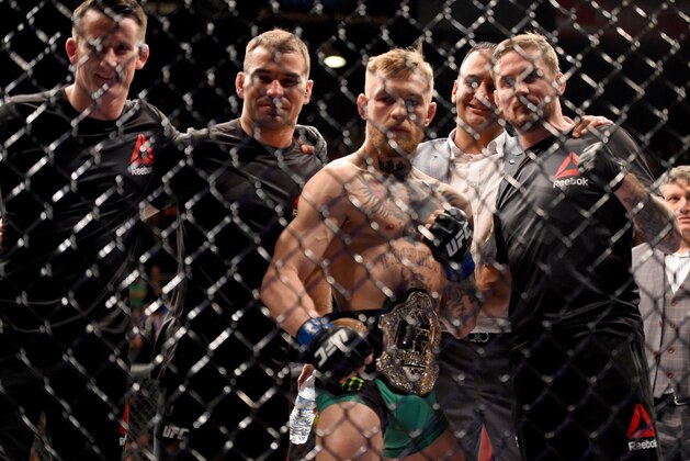 LAS VEGAS, NEVADA - DECEMBER 12:  Conor McGregor of Ireland (2nd from right) celebrates with his coach John Kavanaugh (R) after defeating Jose Aldo of Brazil in their featherweight championship bout during the UFC 194 event inside MGM Grand Garden Arena on December 12, 2015 in Las Vegas, Nevada.  (Photo by Jeff Bottari/Zuffa LLC/Zuffa LLC via Getty Images)