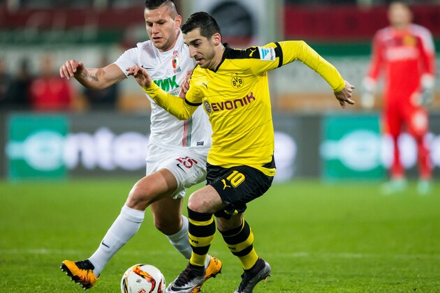 AUGSBURG, GERMANY - MARCH 20:  Henrikh Mkhitaryan of Dortmund is challenged by Raul Bobadilla of Augsburg during the Bundesliga match between FC Augsburg and Borussia Dortmund at SGL Arena on March 20, 2016 in Augsburg, Germany.  (Photo by Simon Hofmann/Getty Images)