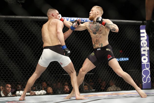 Nate Diaz, left, trades punches with Conor McGregor during their UFC 196 welterweight mixed martial arts match, Saturday, March 5, 2016, in Las Vegas. (AP Photo/Eric Jamison)