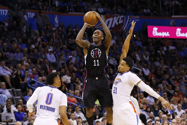 Los Angeles Clippers guard Jamal Crawford (11) shoots a three point ball between Oklahoma City Thunder guard Russell Westbrook (0) and  guard Andre Roberson (21) during the first quarter of an NBA basketball game in Oklahoma City, Thursday, March 31, 2016. (AP Photo/Alonzo Adams)