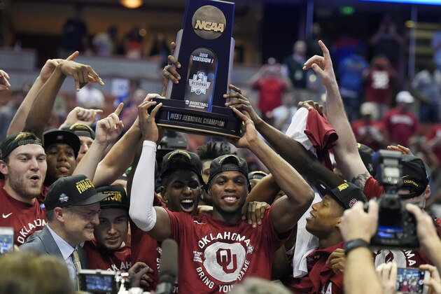 Oklahoma guard Buddy Hield, center, holds the trophy after their win against Oregon during an NCAA college basketball game in the regional finals of the NCAA Tournament, Saturday, March 26, 2016, in Anaheim, Calif.(AP Photo/Mark J. Terrill)