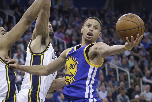 Golden State Warriors guard Stephen Curry (30) reaches for rebound as Utah Jazz center Rudy Gobert, center rear, defends during the second half of an NBA basketball game Wednesday, March 30, 2016, in Salt Lake City. The Warriors won 103-96 in overtime. (AP Photo/Rick Bowmer)