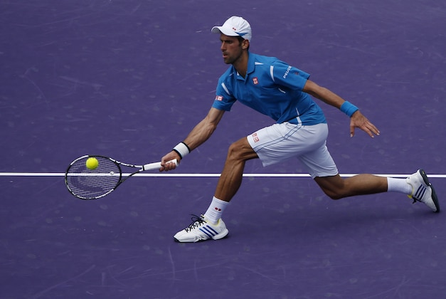 Apr 1, 2016; Key Biscayne, FL, USA; Novak Djokovic hits a volley against David Goffin (not pictured) during a men's singles semifinal on day twelve of the Miami Open at Crandon Park Tennis Center. Mandatory Credit: Geoff Burke-USA TODAY Sports