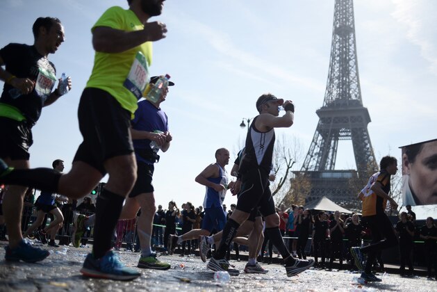 Competitors in the 39th Paris Marathon runs past the Eiffel Tower in Paris on April 12, 2015.  Mark Korir of Kenya won the Paris Marathon, his first career victory in a prestigious international race. Korir, 30, who was second in last month's Paris Half-Marathon, came home in a time of 2hr 05min 46sec, ahead of another Kenyan, Luka Kanda. Seboka Tola of Ethiopia was third, with yet another Kenyan, Mike Kigen, fourth.  AFP PHOTO / STEPHANE DE SAKUTIN        (Photo credit should read STEPHANE DE SAKUTIN/AFP/Getty Images)