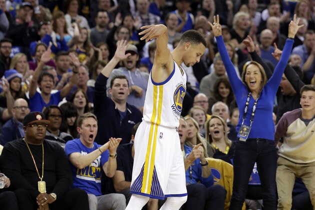 The crowd reacts after Golden State Warriors' Stephen Curry, center, made a 3-point basket during the first half of an NBA basketball game against the Boston Celtics on Friday, April 1, 2016, in Oakland, Calif. (AP Photo/Marcio Jose Sanchez)