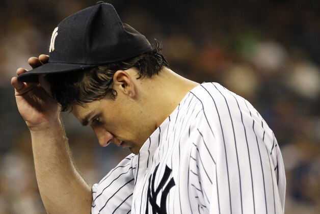 New York Yankees starting pitcher Nathan Eovaldi touches his cap as he enters the dugout in the fifth inning of a baseball game against the Houston Astros at Yankee Stadium in New York, Monday, Aug. 24, 2015.  (AP Photo/Kathy Willens)
