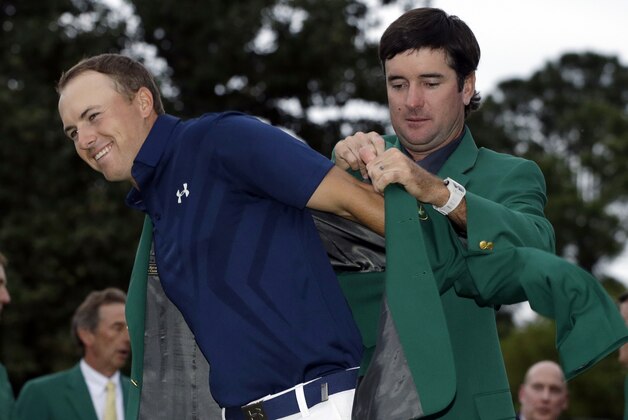 ADVANCE FOR WEEKEND EDITIONS, APRIL 2-3 - In this April 12, 2016, file photo, Bubba Watson, right, helps Jordan Spieth put on his green jacket for the second time after winning the Masters golf tournament in Augusta, Ga. His intelligence on the golf course might be a big reason that Spieth last year became the youngest player in nearly a century to win two majors at age 21. (AP Photo/Darron Cummings, File)