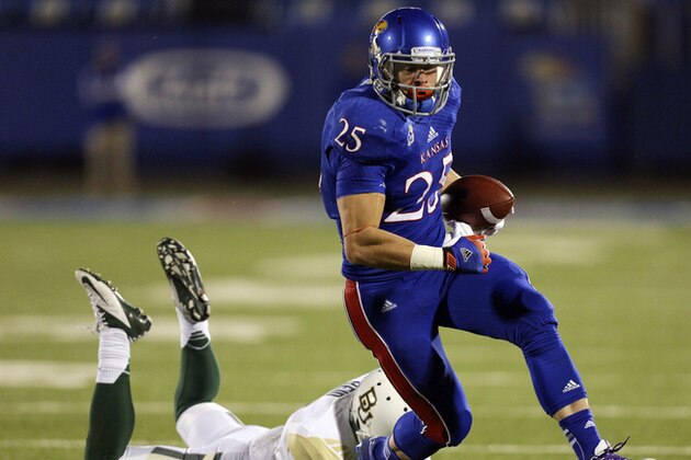 Kansas Jayhawks running back Brandon Bourbon (25) slips past Baylor Bears cornerback Ryan Reid for a touchdown in the third quarter of an NCAA college football game Saturday, Oct. 26, 2013, in Lawrence, Kan. Baylor won 59-14. (AP Photo/Ed Zurga)