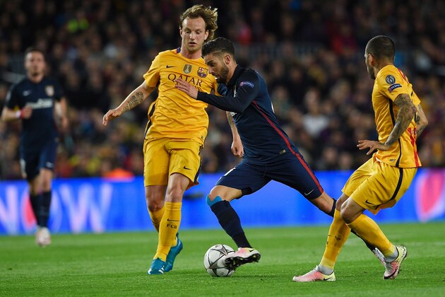 Barcelona's Croatian midfielder Ivan Rakitic (L) and Barcelona's Brazilian defender Dani Alves (R) vie with Atletico Madrid's Belgian midfielder Yannick Ferreira Carrasco during the UEFA Champions League quarter finals first leg football match FC Barcelona vs Atletico de Madrid at the Camp Nou stadium in Barcelona on April 5, 2016. / AFP / LLUIS GENE        (Photo credit should read LLUIS GENE/AFP/Getty Images)