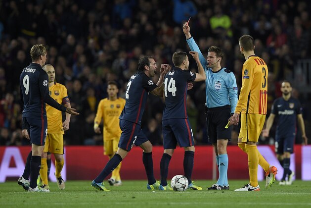 German referee Felix Brych (2ndR) shows a red card to Atletico Madrid's forward Fernando Torres (L) during the UEFA Champions League quarter finals first leg football match FC Barcelona vs Atletico de Madrid at the Camp Nou stadium in Barcelona on April 5, 2016. / AFP / LLUIS GENE        (Photo credit should read LLUIS GENE/AFP/Getty Images)
