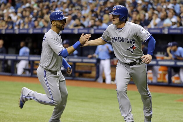 Toronto Blue Jays' Josh Donaldson, right, and Jose Bautista celebrate after scoring on a two-run single by Edwin Encarnacion off Tampa Bay Rays starting pitcher Chris Archer during the first inning of a baseball game Sunday, April 3, 2016, in St. Petersburg, Fla. (AP Photo/Chris O'Meara)