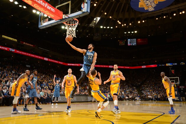 OAKLAND, CA - APRIL 5: Karl-Anthony Towns #32 of the Minnesota Timberwolves shoots a layup against Stephen Curry #30 of the Golden State Warriors on April 5, 2016 at Oracle Arena in Oakland, California. NOTE TO USER: User expressly acknowledges and agrees that, by downloading and or using this photograph, user is consenting to the terms and conditions of Getty Images License Agreement. Mandatory Copyright Notice: Copyright 2016 NBAE (Photo by Noah Graham/NBAE via Getty Images)