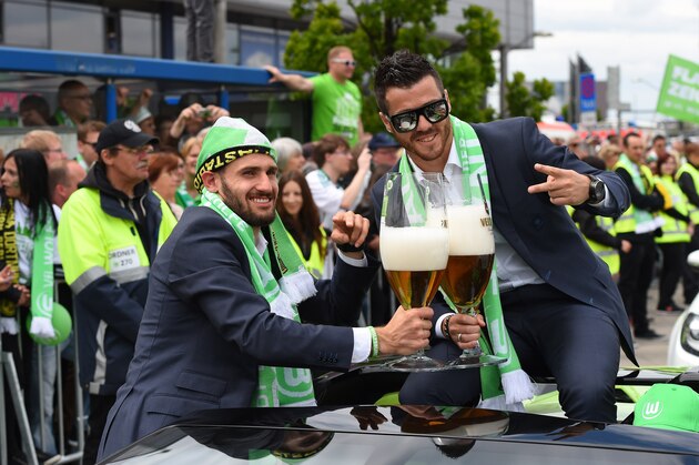 Wolfsburg's midfielder Daniel Caligiuri (L) and Wolfsburg's Portuguese striker Vieirinha pose with large beer glasses on the team's arrival in Wolfsburg, central Germany on May 31, 2015, after the German Cup DFB Pokal final football match between BVB Borussia Dortmund and VfL Wolfsburg on May 30 in Berlin. Wolfsburg won the match 1-3. AFP PHOTO / TOBIAS SCHWARZ        (Photo credit should read TOBIAS SCHWARZ/AFP/Getty Images)