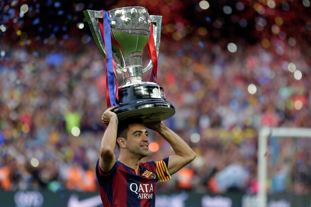 FC Barcelona's Xavi Hernandez holds up the trophy after winning the Spanish League title, at the end of their Spanish La Liga last round soccer match against Deportivo Coruna at the Camp Nou stadium in Barcelona, Spain, Saturday, May 23, 2015. (AP Photo/Manu Fernandez)